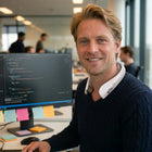 MaxoRize Professional X worn by man smiling at desk in open office